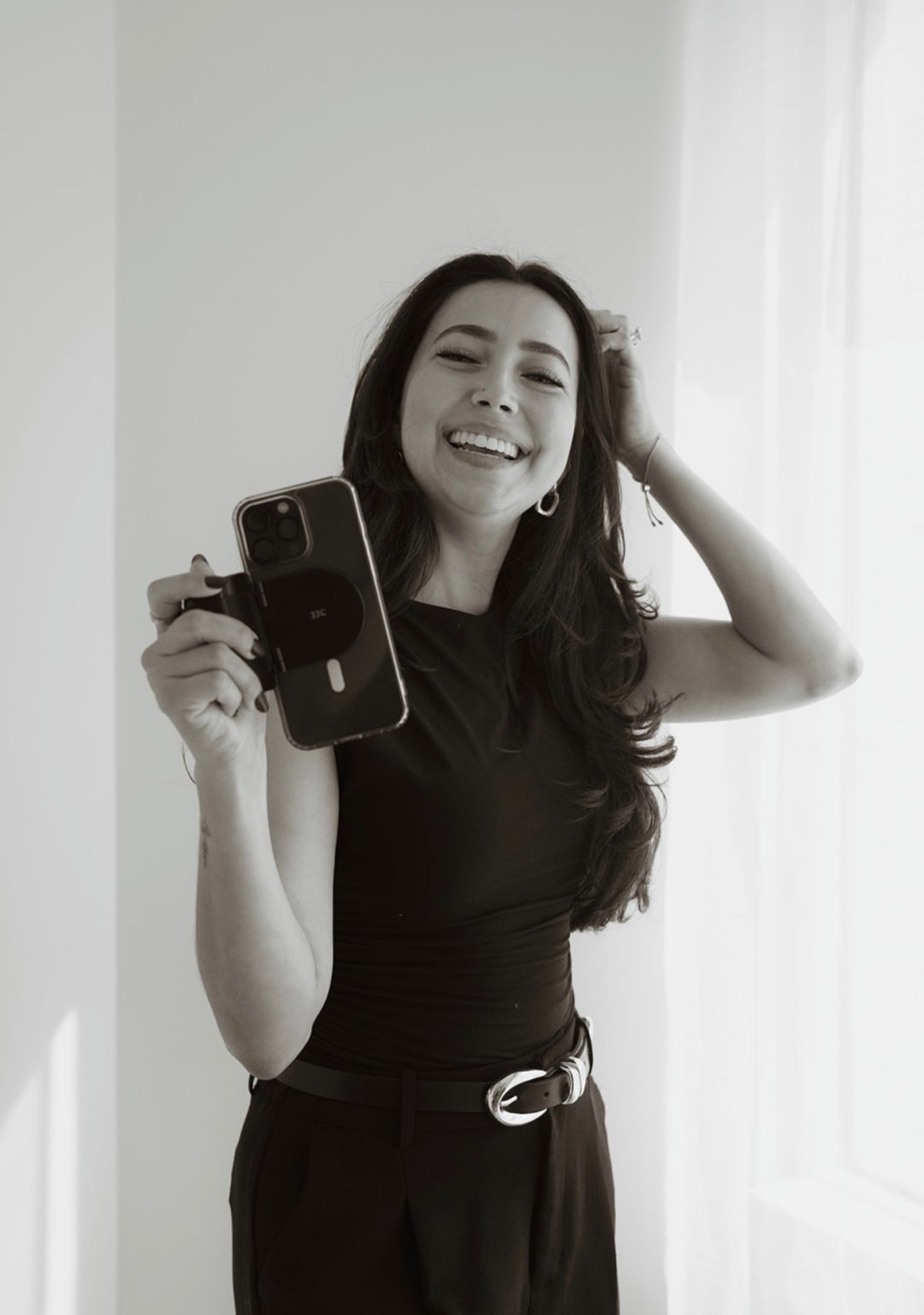 Associate creator laughing and holding a phone camera rig
