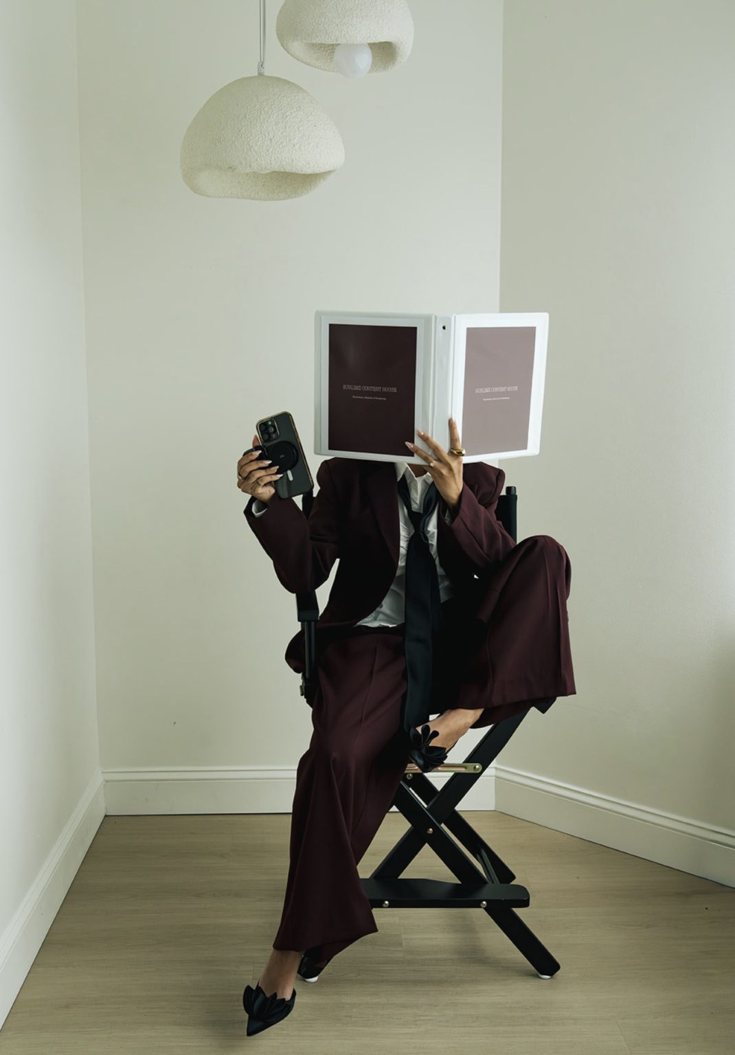 Annie in a director's chair hiding behind a Sublime Content House binder